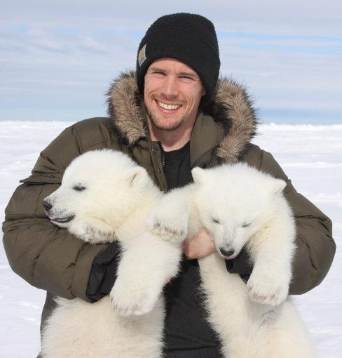 约翰·怀特曼抱着北极熊幼崽